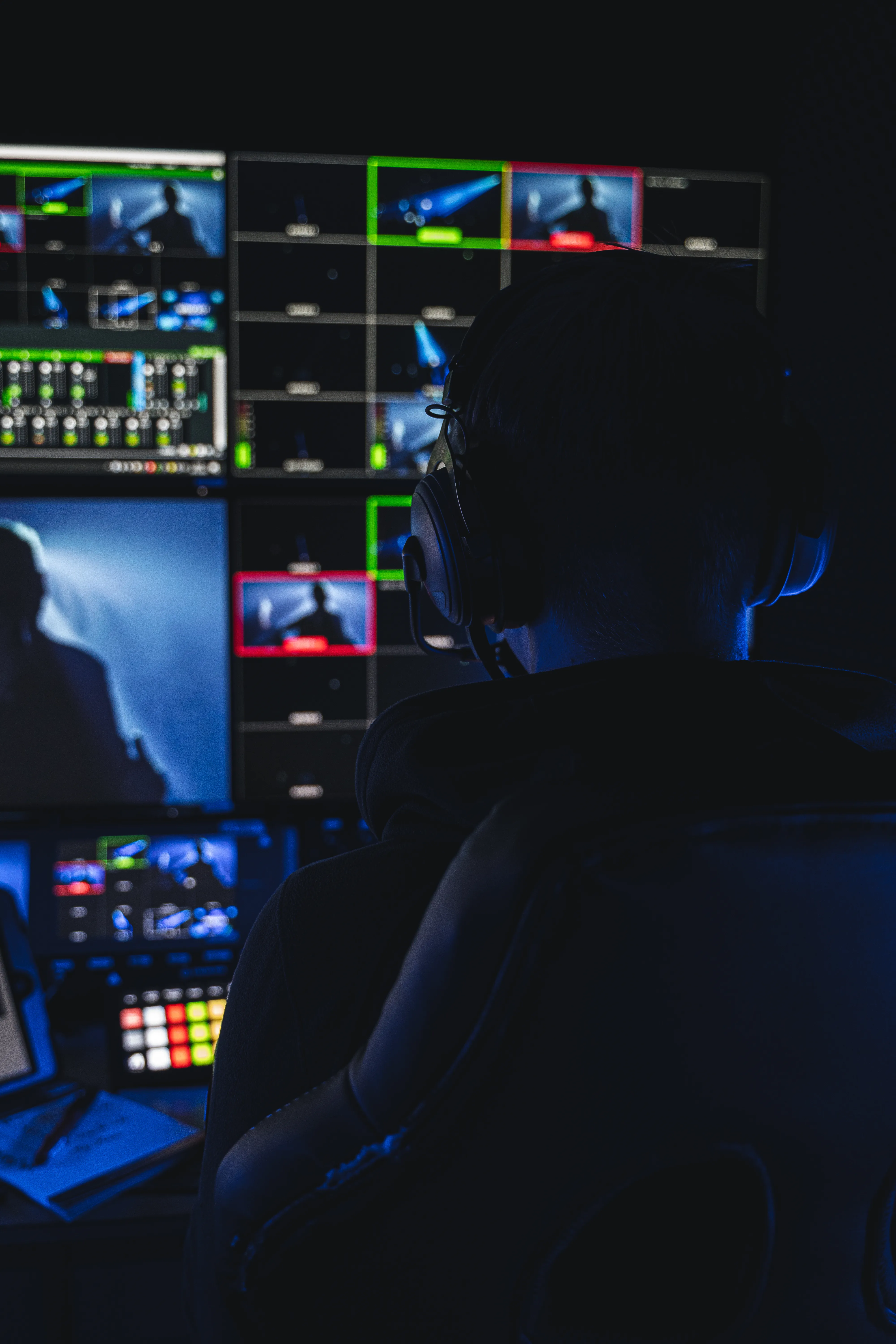 Mann vor Bildschirmen in einem Übertragungswagen