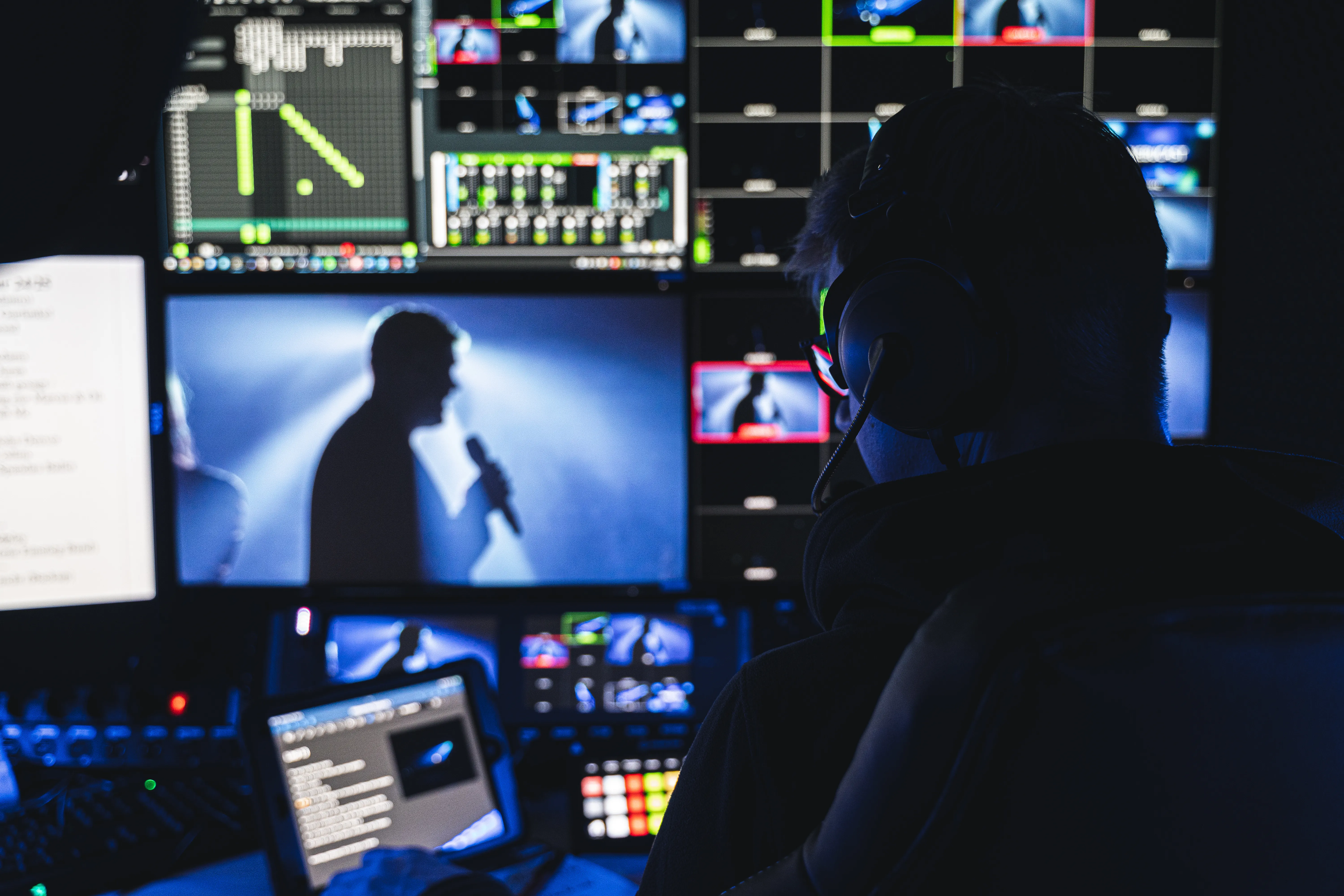 Mann vor Bildschirmen in einem Übertragungswagen